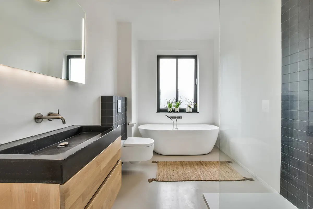 Modernes Badezimmer in hellen Farben mit dunklem Waschbecken und dunklen Flieseneinsätzen