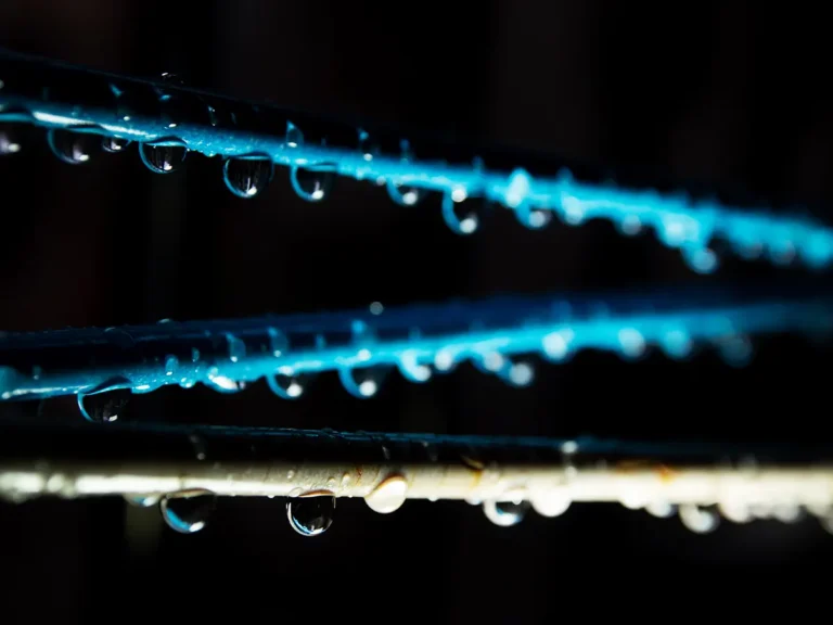 Nahaufnahme von Wassertropfen, die von einem Rohr herabfließen
