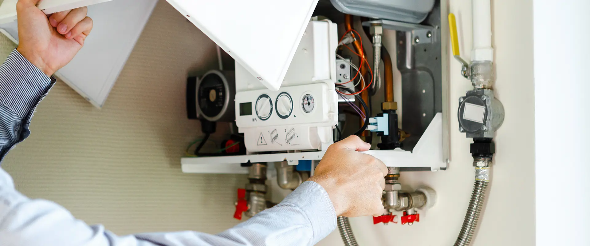 pur - Gasinstallateur - header Ein Mann repariert einen Wasserboiler in einem technischen Arbeitsumfeld