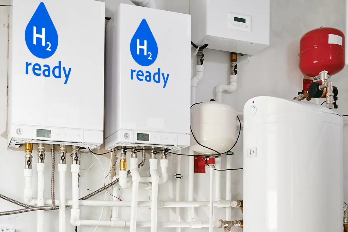 Zwei weiße Boiler und ein Wassererhitzer stehen in einem Raum