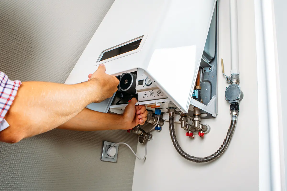 Ein Mann installiert einen Gasboiler