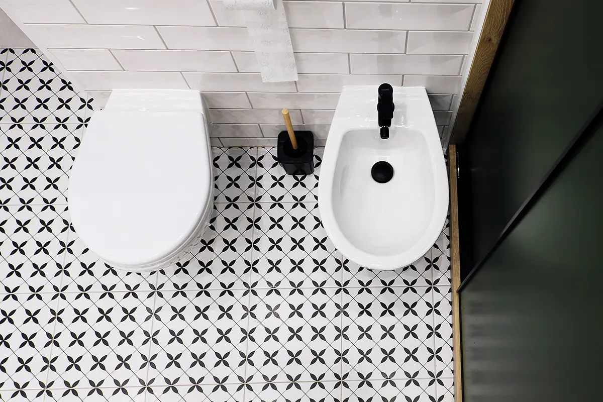 pur - Toiletten-Typen für jeden Bedarf Badezimmer mit weißer Toilette und schwarz-weißen Fliesenboden